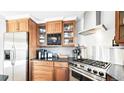 This kitchen features wood cabinets, granite countertops, stainless appliances, and tile backsplash at 76 Buckthorn Dr, Littleton, CO 80127