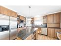 A traditional kitchen with wood cabinets, stainless steel appliances and granite countertops on the island at 76 Buckthorn Dr, Littleton, CO 80127