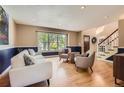 Inviting living room featuring hardwood floors, a large window, and cozy seating arrangement at 5 Cliffrose, Littleton, CO 80127