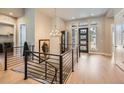 Bright foyer with wood floors, modern chandelier, and staircase featuring iron railings at 1766 Summerglow Ln, Monument, CO 80132