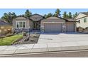 Attractive stucco home featuring a three-car garage, stone accents, and mature trees at 1766 Summerglow Ln, Monument, CO 80132