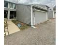 Gray two-story townhome with two-car garage, inviting entrance, and trimmed landscaping at 12973 E Cornell Ave, Aurora, CO 80014