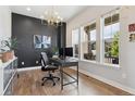 Well-lit office space with dark accent wall and modern chandelier at 20998 E 60Th Pl, Aurora, CO 80019