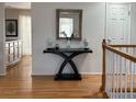 Inviting entryway featuring hardwood floors, a decor table with mirror, and a light-filled ambiance at 3643 E Lake Dr, Centennial, CO 80121
