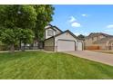 Charming exterior showcasing the lawn and three-car garage on a sunny day at 17303 E Dewberry Cir, Parker, CO 80134