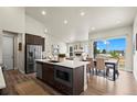 Modern kitchen open to dining room with stainless steel appliances and ample counter space at 8244 S Queen St, Littleton, CO 80127