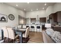 Open concept living room and dining area with modern decor and hardwood floors at 8244 S Queen St, Littleton, CO 80127