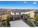 Desirable two-story home boasts a three-car garage, brick facade, landscaping, and a prime location near a pond at 7207 S Scottsburg Way, Aurora, CO 80016