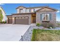 Charming two-story home featuring a three-car garage, brick facade, landscaped yard and inviting front door at 7207 S Scottsburg Way, Aurora, CO 80016