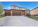 Charming two-story home featuring a three-car garage, brick facade, landscaped yard and inviting front door at 7207 S Scottsburg Way, Aurora, CO 80016