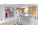 Bright kitchen features a central island, and stairs leading to the upper levels at 10538 Quivas St, Northglenn, CO 80234
