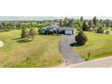 Expansive aerial view of a home, showcasing its large lawn and extended driveway at 9232 N Surrey Dr, Castle Rock, CO 80108