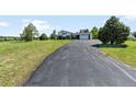 View of the long driveway leading up to the home with a two car garage and a green lawn at 9232 N Surrey Dr, Castle Rock, CO 80108