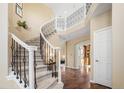Elegant foyer featuring a curved staircase and hardwood floors at 7624 Russell Ct, Arvada, CO 80007