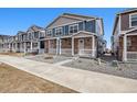 Charming two-story home featuring stone accents, a cozy front porch, and low-maintenance landscaping at 22384 E 6Th Pl, Aurora, CO 80018