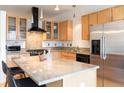 Bright kitchen featuring stainless steel appliances, granite counters, and wooden cabinets with glass fronts at 1438 Little Raven St # 301, Denver, CO 80202