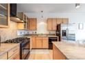 The well-lit kitchen shows a stainless steel refrigerator, wooden cabinets, granite countertops, and a gas cooktop at 1438 Little Raven St # 301, Denver, CO 80202
