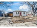 Inviting home with a red front door, carport, and well-kept front yard at 4573 S Acoma St, Englewood, CO 80110
