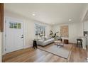 Bright living room with hardwood floors, white sofa, neutral rug, and modern decor at 4573 S Acoma St, Englewood, CO 80110