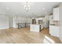 Bright open-concept living room and kitchen area, boasting hardwood floors and modern lighting at 17196 W 92Nd Loop, Arvada, CO 80007