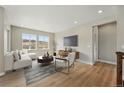 Bright living room featuring hardwood floors, stylish furniture, and large windows at 17196 W 92Nd Loop, Arvada, CO 80007