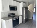Well-lit kitchen with white cabinets, stainless steel appliances, and gray countertops at 1642 N Lafayette St # 2, Denver, CO 80218