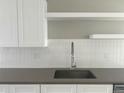 Modern kitchen sink and countertop with white cabinets and backsplash at 1642 N Lafayette St # 2, Denver, CO 80218
