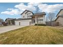 Attractive two-story home with a covered porch, manicured lawn, and a convenient two-car garage at 5826 Sunburst Ave, Firestone, CO 80504