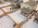 Aerial view of homes with fenced backyards and some snow cover at 656 N Bersshine St, Watkins, CO 80137