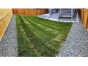 Spacious backyard with grassy lawn, gravel borders, and wooden fence at 656 N Bersshine St, Watkins, CO 80137