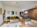 Spacious living room with hardwood floors, exposed brick wall, and open concept design at 1217 E 26Th Ave, Denver, CO 80205