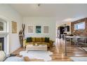 Comfortable living room with hardwood floors, exposed brick, and open view to the kitchen at 1217 E 26Th Ave, Denver, CO 80205