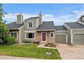 Charming exterior view of the home with stone accents, lush lawn, and attached garage at 4720 S Dudley St # 44, Littleton, CO 80123