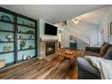 Open-concept living room with a fireplace, stairs to the second floor, and hardwood floors at 4720 S Dudley St # 44, Littleton, CO 80123