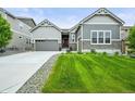 A well-manicured lawn enhances this beautiful home, complete with a two-car attached garage and welcoming front entrance at 16256 Ute Peak Way, Broomfield, CO 80023