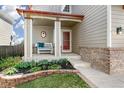 Inviting front porch with seating and landscaping with flowers near a red front door at 4150 S Rome St, Aurora, CO 80018