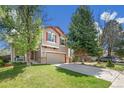 Two-story home with a well-maintained lawn, mature trees, and a driveway leading to a two-car garage at 4150 S Rome St, Aurora, CO 80018