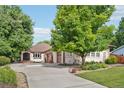 Inviting home with a well-manicured lawn, mature trees, and an attached three-car garage at 2069 Garrison St, Lakewood, CO 80215