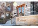 Inviting condo entrance with stone facade, copper awning, and clear signage at 111 S Monroe St # B104, Denver, CO 80209