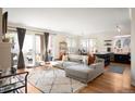 Bright and airy living room with open floor plan, balcony access, and hardwood floors at 111 S Monroe St # B104, Denver, CO 80209