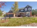 Beautiful two-story home with brick and siding, well-kept lawn, and attached three-car garage at 404 Yarrow Pl, Castle Pines, CO 80108