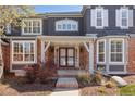 Inviting front porch with brick and wood accents, offering a warm welcome at 404 Yarrow Pl, Castle Pines, CO 80108