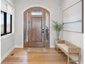 Inviting entryway featuring a wooden front door with sidelights, hardwood floors, bench seating, and stylish decor at 15322 Irving Ct, Broomfield, CO 80023