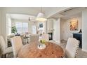 Dining area with a rustic wood table, upholstered chairs, and views into the living area at 1767 N Pearl St # 308, Denver, CO 80203