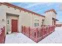 Inviting entryway featuring a red door, decorative fence, and snowy patio at 1767 N Pearl St # 308, Denver, CO 80203