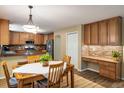 Cozy dining room adjacent to kitchen features wooden table, stylish lighting, and built in desk at 19815 E Progress Ln, Centennial, CO 80015