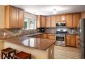 Well-appointed kitchen features granite countertops, stainless steel appliances, and custom wood cabinetry at 19815 E Progress Ln, Centennial, CO 80015