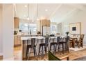Bright, modern kitchen with stainless steel appliances, island, and open to the dining area at 6472 W Brittany Pl, Littleton, CO 80123