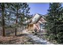 Charming two-story home with brick and siding exterior, mature trees and walkway, set in nature at 870 Homestake Ct, Castle Rock, CO 80108