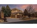A three car garage with brick accents and mature landscaping at 9368 S Silent Hills Dr, Lone Tree, CO 80124